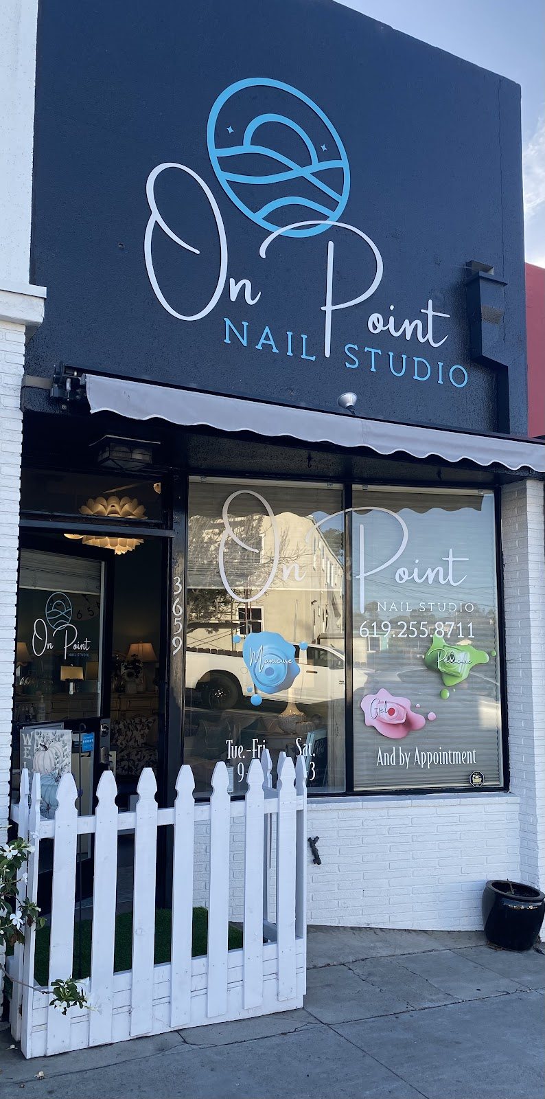 On Point Nail Studio storefront on Voltaire Street with a white picket fence